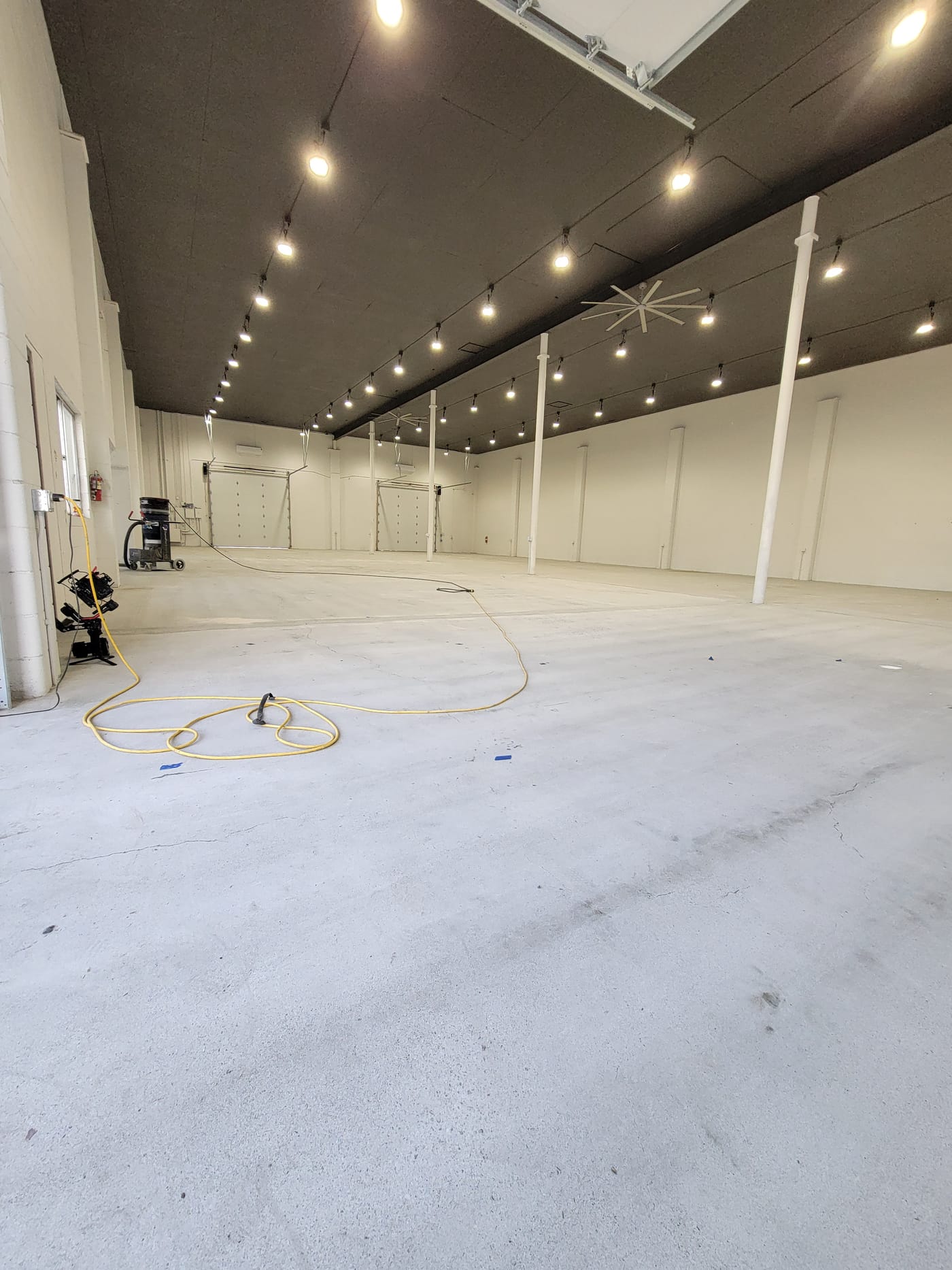 Large commercial concrete floor before surface preparation and flake coating installation.