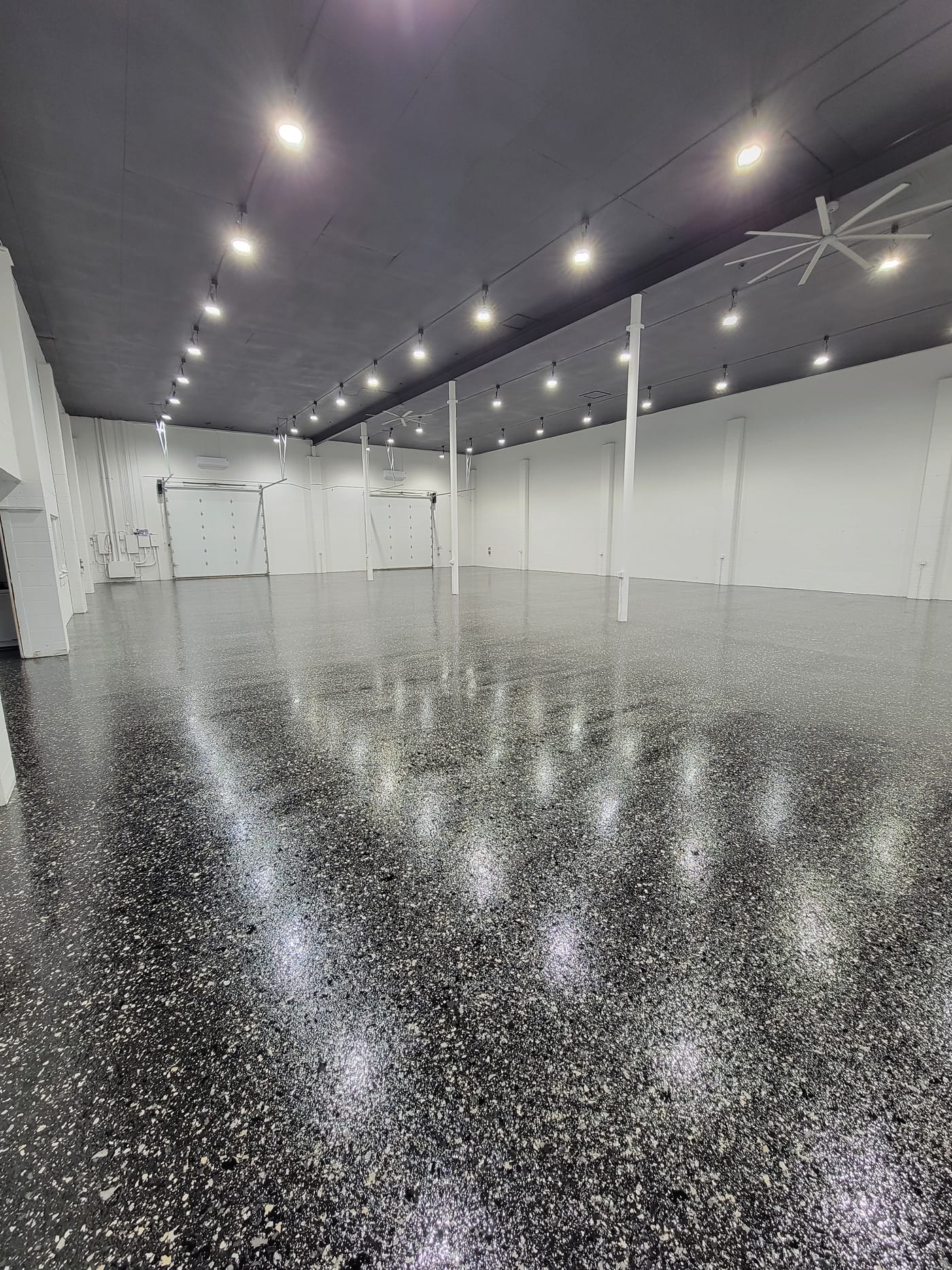Large commercial floor after a glossy black and gray decorative flake coating installation.