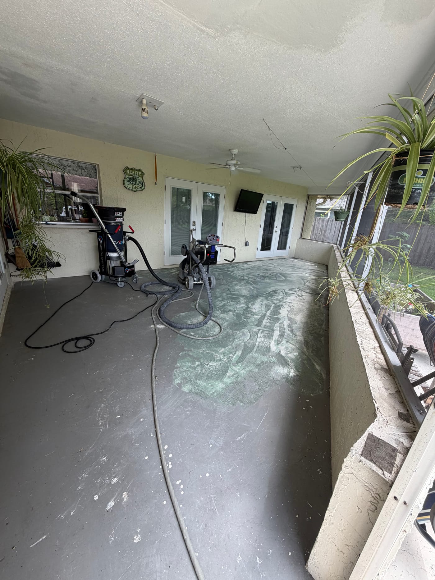 Screened patio floor during surface preparation before a decorative coating installation.