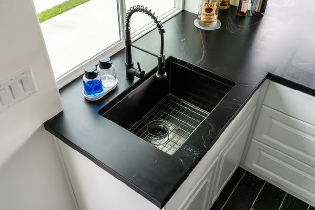 Black kitchen countertop coating installed around a sink.