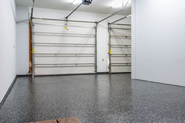 Garage floor finished with a dark decorative flake coating.