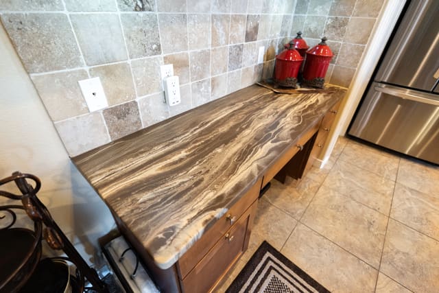 Warm wood-look kitchen countertop coating beside a tile backsplash.