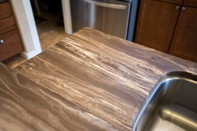 Wood-look epoxy countertop coating installed beside a kitchen sink.