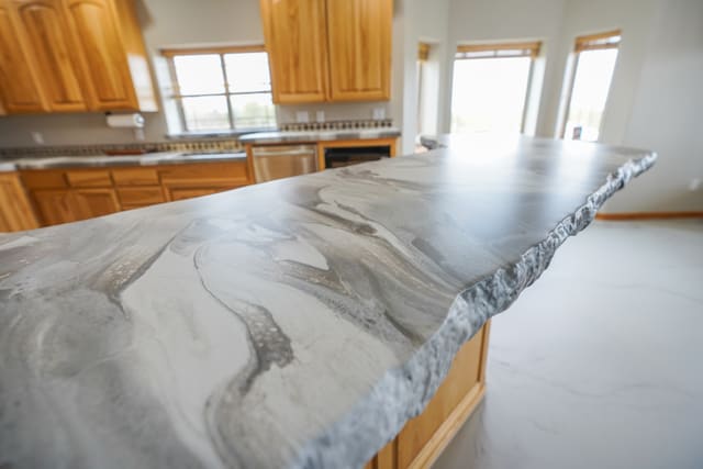 Large kitchen island with a gray marble-look epoxy countertop.