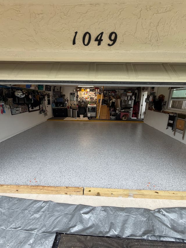 Completed residential garage floor with a clean gray decorative flake coating.