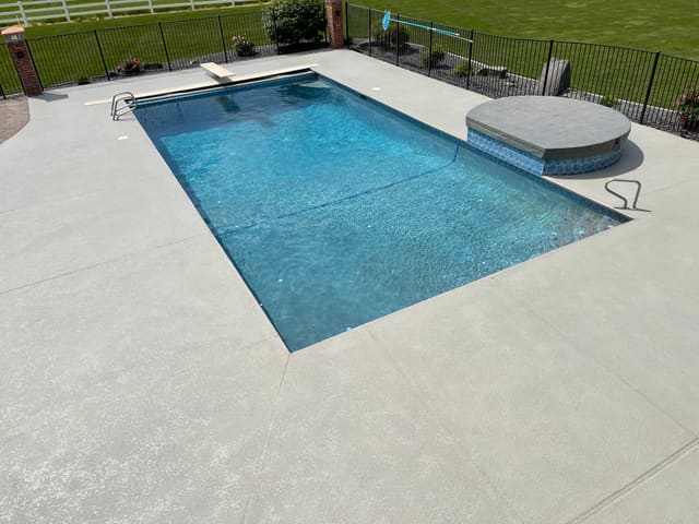 Pool surround concrete finished with a light textured coating.