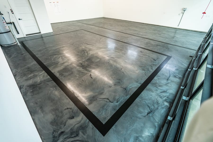 Decorative concrete floor with a dark border detail and polished finish.